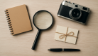 탐정사무소를 상징하는 돋보기, 노트, 빈 봉투, 빈티지 카메라가 배열된 탐정 소품 평면 사진